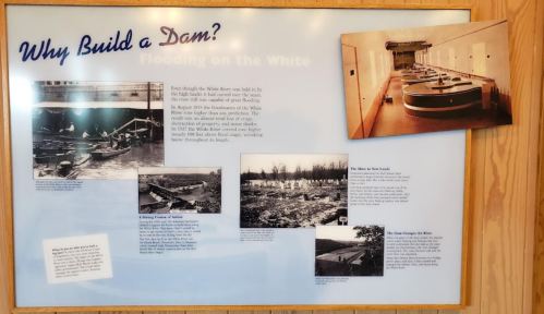 Informational display about dam construction, featuring historical photos and text on flooding in the White River area.