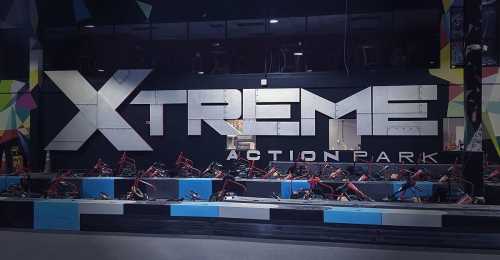 A vibrant indoor go-kart track at Xtreme Action Park, featuring colorful walls and parked go-karts.