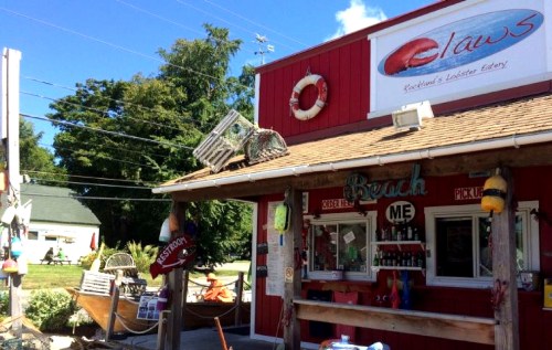 A red seafood eatery with a lobster theme, featuring outdoor seating and nautical decor.