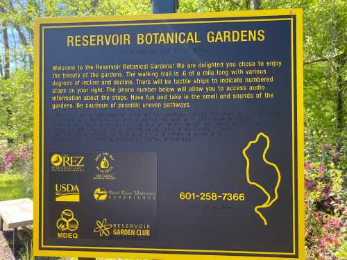 Sign for Reservoir Botanical Gardens, detailing walking trail info, contact number, and safety reminders for visitors.