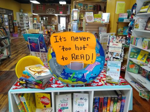 A colorful display in a bookstore promoting reading with a sign that says, "It's never 'too hot' to READ!"