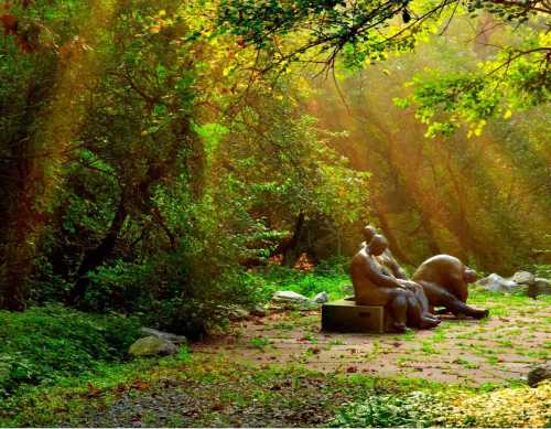 A serene forest scene featuring two sculptures seated on a path, surrounded by lush greenery and soft sunlight.