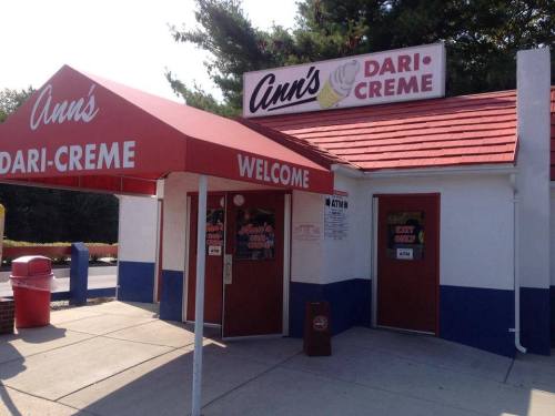 A small ice cream shop with a red awning and sign reading "Ann's Dari-Creme," featuring a welcoming entrance.