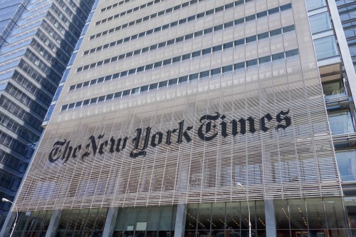 The facade of The New York Times building featuring its iconic logo in large letters.