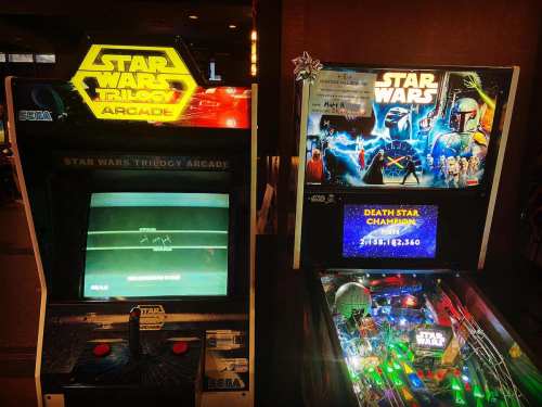 Two arcade machines featuring "Star Wars" games: one is a video game, the other a pinball machine with colorful lights.