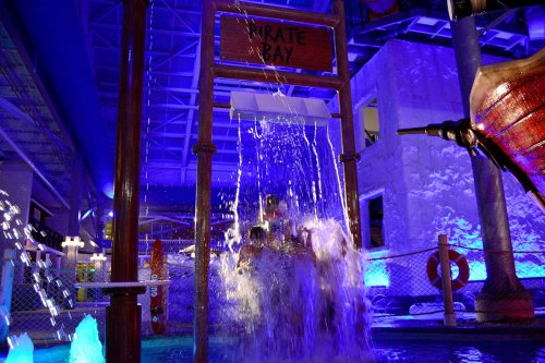 A water feature at Pirate Bay, with cascading water and colorful lighting, creating a fun atmosphere.