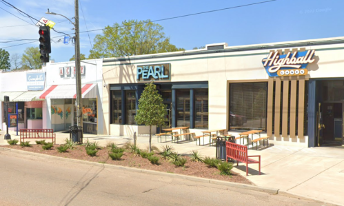 A street view of two restaurants, The Pearl and Highball, with outdoor seating and a clear blue sky.
