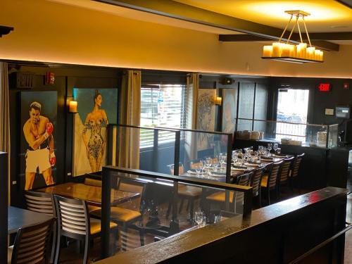 Interior of a restaurant featuring artistic wall decor and a set dining area with tables and chairs.