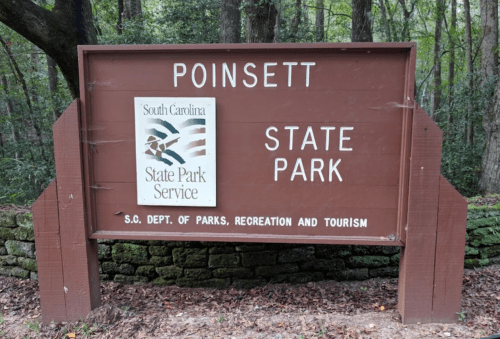Sign for Poinsett State Park in South Carolina, featuring the state park logo and information about the park service.