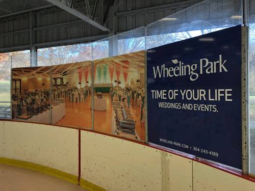 Banner promoting Wheeling Park for weddings and events, displayed in an ice rink.