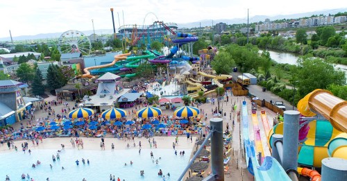 Aerial view of a vibrant water park with slides, pools, and crowds enjoying a sunny day.