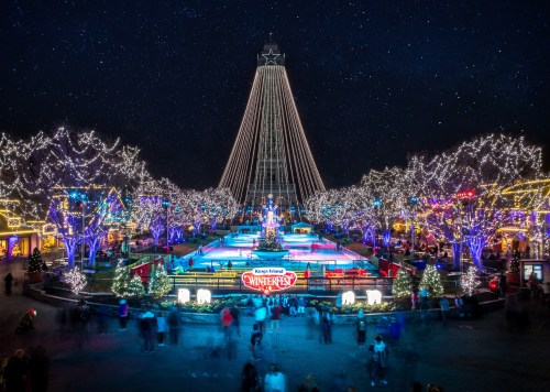 A festive winter scene with an ice rink, twinkling lights, and a large Christmas tree under a starry night sky.