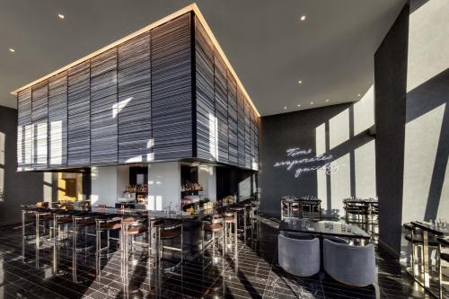 Modern restaurant interior featuring sleek design, a bar area, and stylish seating with large windows.