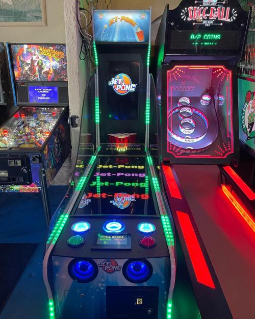 A brightly lit arcade game featuring "Jet Pons" and "Skee-Ball" machines in a game room setting.