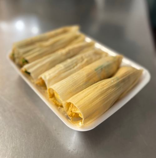 A plate of tamales wrapped in corn husks, showcasing a variety of fillings.