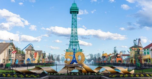 A colorful replica of the Eiffel Tower stands in a park, celebrating a 50th anniversary with festive decorations.