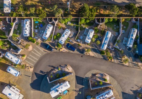 Aerial view of a trailer park with several RVs and landscaped areas along winding roads.