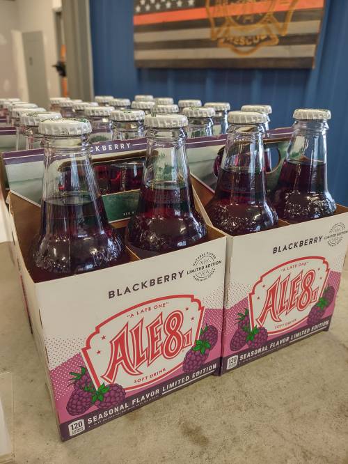 A display of Ale-8-One Blackberry soda bottles in a seasonal limited edition packaging.