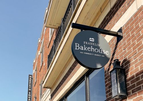 Exterior of Franklin Bakehouse with a sign, featuring brick architecture and clear blue sky.