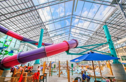 Indoor water park featuring colorful water slides, a large pool area, and a bright, airy atmosphere.