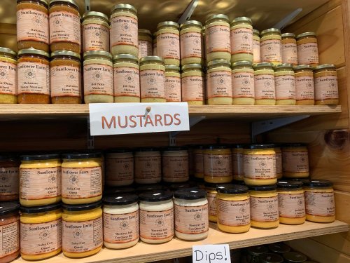 Shelves filled with jars of various mustards and dips, all labeled from Sunflower Farm.