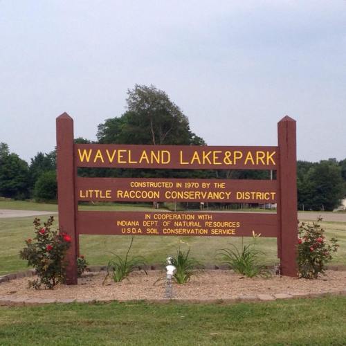 Sign for Waveland Lake & Park, established in 1970 by the Little Raccoon Conservancy District, with surrounding greenery.