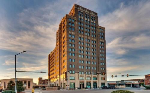 Historic tall building with a brick facade, set against a colorful sky at sunset.