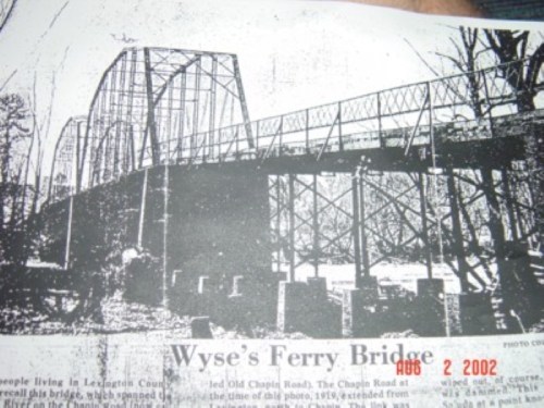 Black and white photo of Wyse's Ferry Bridge, showcasing its truss design and surrounding landscape.