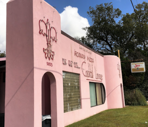 A pink building with "Roman Pizza" and "Cocktail Lounge" signs, featuring a curved window and decorative elements.