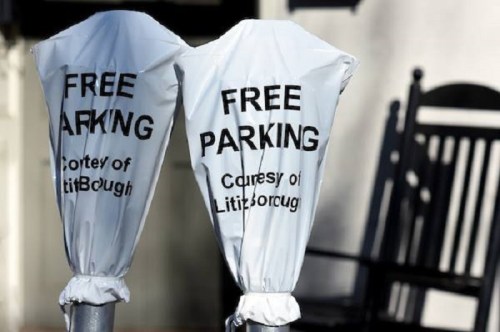 Two parking signs wrapped in white plastic, both stating "FREE PARKING" and "Courtesy of Lititz Borough."