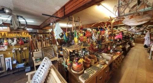 A vibrant shop filled with colorful decorations, tools, and crafts, showcasing a variety of handmade items and wooden crafts.