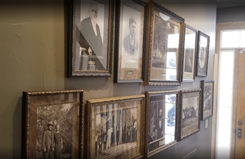 A wall displaying a collection of framed black-and-white historical photographs.