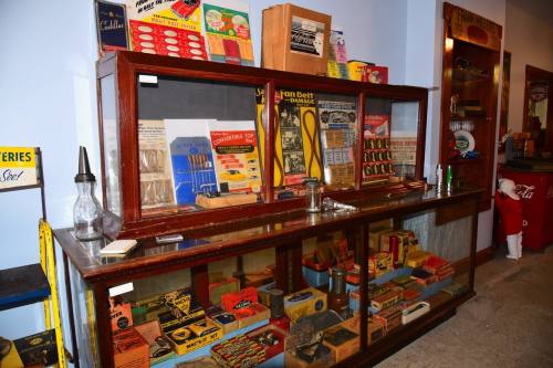 A vintage display case filled with old tools, packaging, and memorabilia in a nostalgic setting.