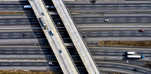 Aerial view of intersecting highways with vehicles traveling on multiple lanes.