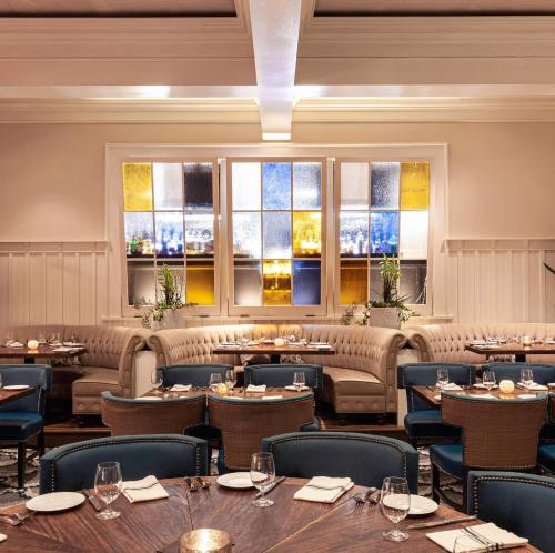Elegant restaurant interior featuring cozy seating, wooden tables, and colorful stained glass windows.
