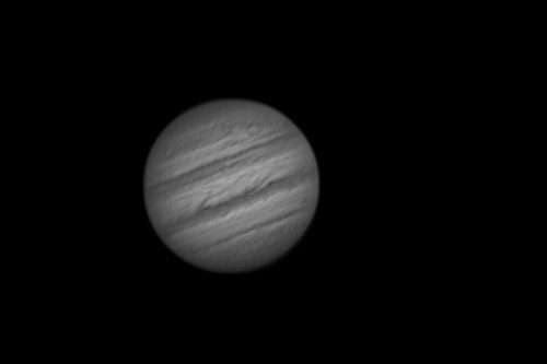 A grayscale image of Jupiter, showcasing its bands and swirling clouds against a black background.