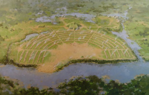 Aerial view of a circular ancient settlement surrounded by water and greenery, featuring organized pathways and structures.