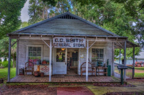 Historic C.C. Smith General Store with a wooden porch, surrounded by trees and vintage decor.