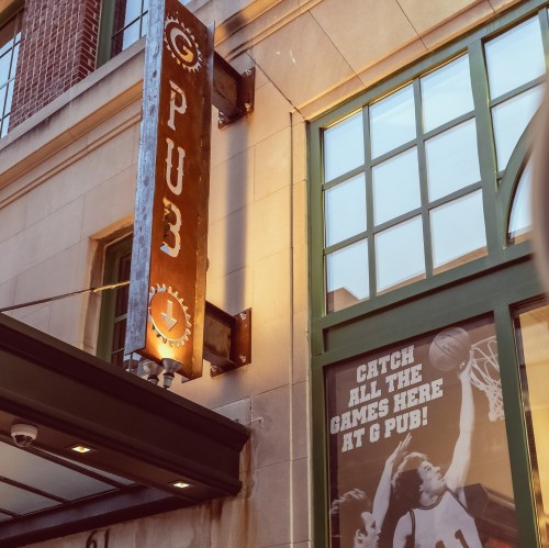 Sign for a pub with "PUB3" displayed, featuring a basketball-themed advertisement on the window.