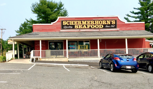 A red seafood market with a sign reading "Schermerhorn's Seafood" and parked cars in front.