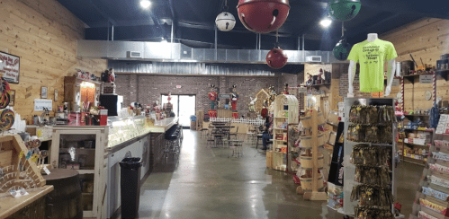 Interior of a colorful store with wooden walls, shelves of snacks, and a seating area. Brightly lit and inviting atmosphere.
