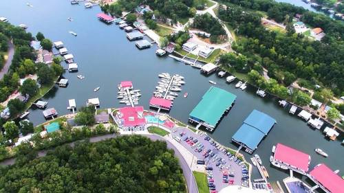 Aerial view of a marina with boats, docks, and green trees surrounding a calm waterway.