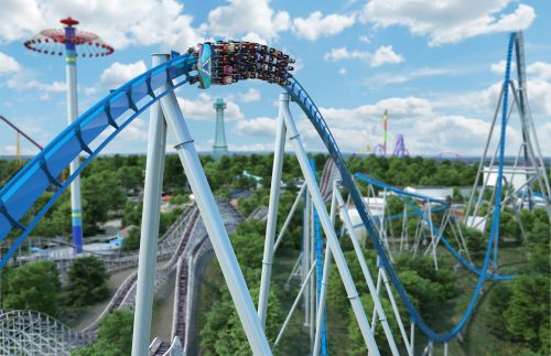 A roller coaster twists and turns above a lush landscape, with amusement park rides in the background under a blue sky.