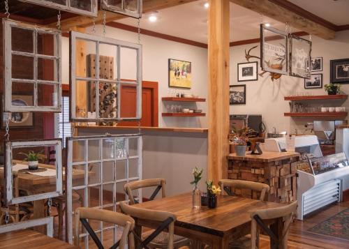 Cozy café interior with wooden tables, rustic decor, and shelves displaying photos and plants. Warm, inviting atmosphere.