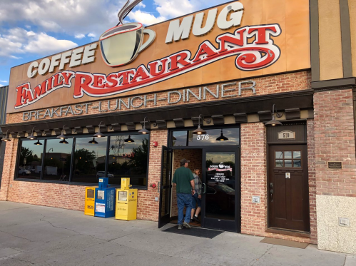 A family restaurant named "Coffee Mug" with a large sign, featuring a man entering the establishment.