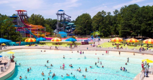 A vibrant water park scene with colorful slides, a wave pool, and people enjoying the sun and water activities.
