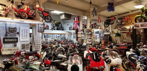A vibrant motorcycle museum filled with various vintage bikes, memorabilia, and British flags adorning the walls.
