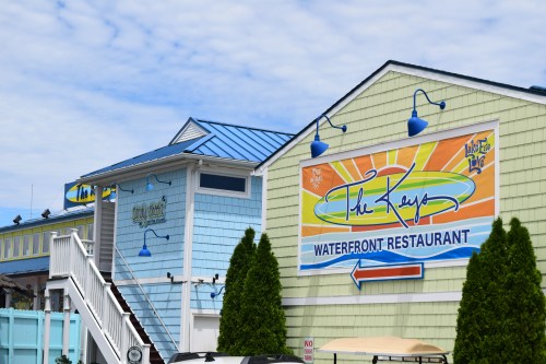 Colorful exterior of The Keys Waterfront Restaurant, featuring a blue roof and vibrant signage.