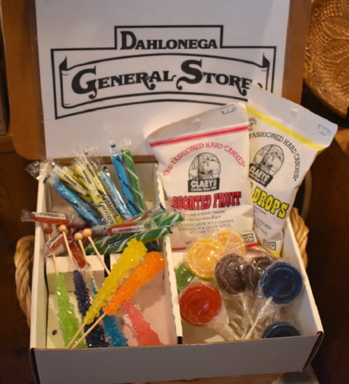 A box of assorted candies, including rock candy, lollipops, and hard candies, from Dahlonega General Store.