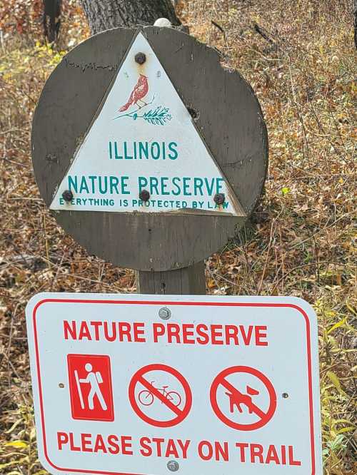 Sign for an Illinois nature preserve, featuring a bird illustration and warnings to stay on the trail.